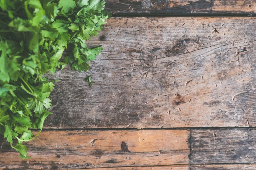 parsley leaves on brown wooden surface